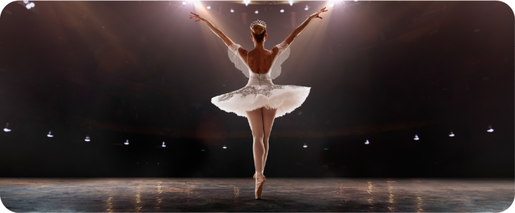 Ballerina balancing en pointe on a spotlit stage