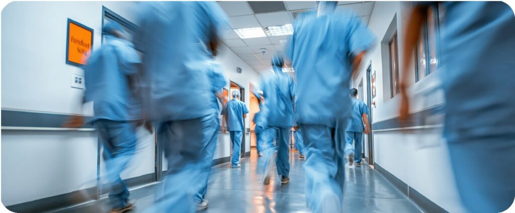 Hospital staff in scrubs rushing down a corridor